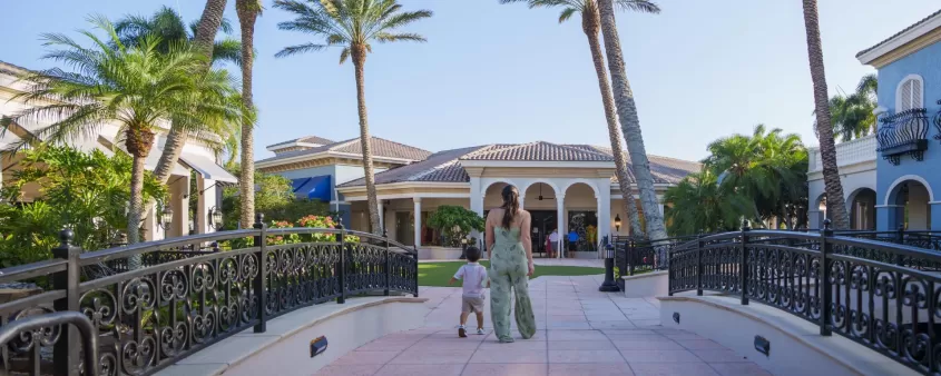 A mother and child walking through an outdoor mall